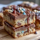 Festive graduation cookie bars topped with vibrant candy-coated chocolates and a glossy white chocolate drizzle, perfect for celebrations.  