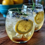 Lavender Lemonade Spritz with ice, sparkling wine, and fresh lavender garnish in a clear glass.
