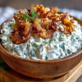 Tangy Fried Pickle Dip topped with crispy pickles and fresh green onions.