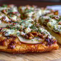Golden-brown mini pizzettes topped with sliced pears, crumbled Gorgonzola, and pickled walnuts. 